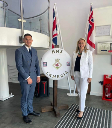 Laura Anne Jones MS and James Evans MS pictured in front of HMS Cambria sign